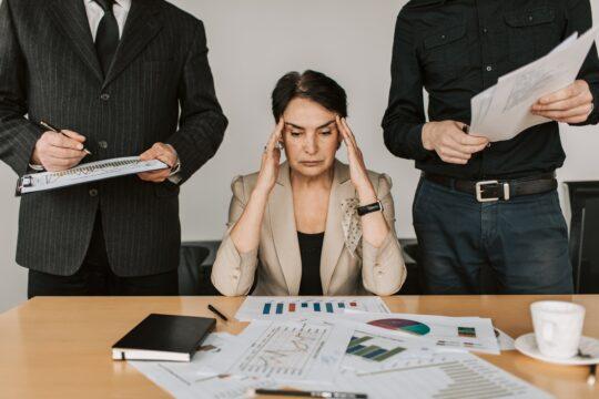 woman holding her head at work